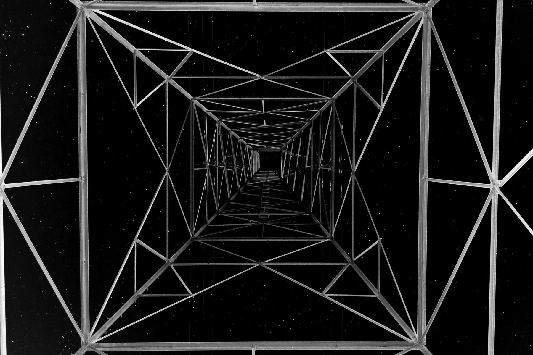 A line of transmission pylons crossing open country.