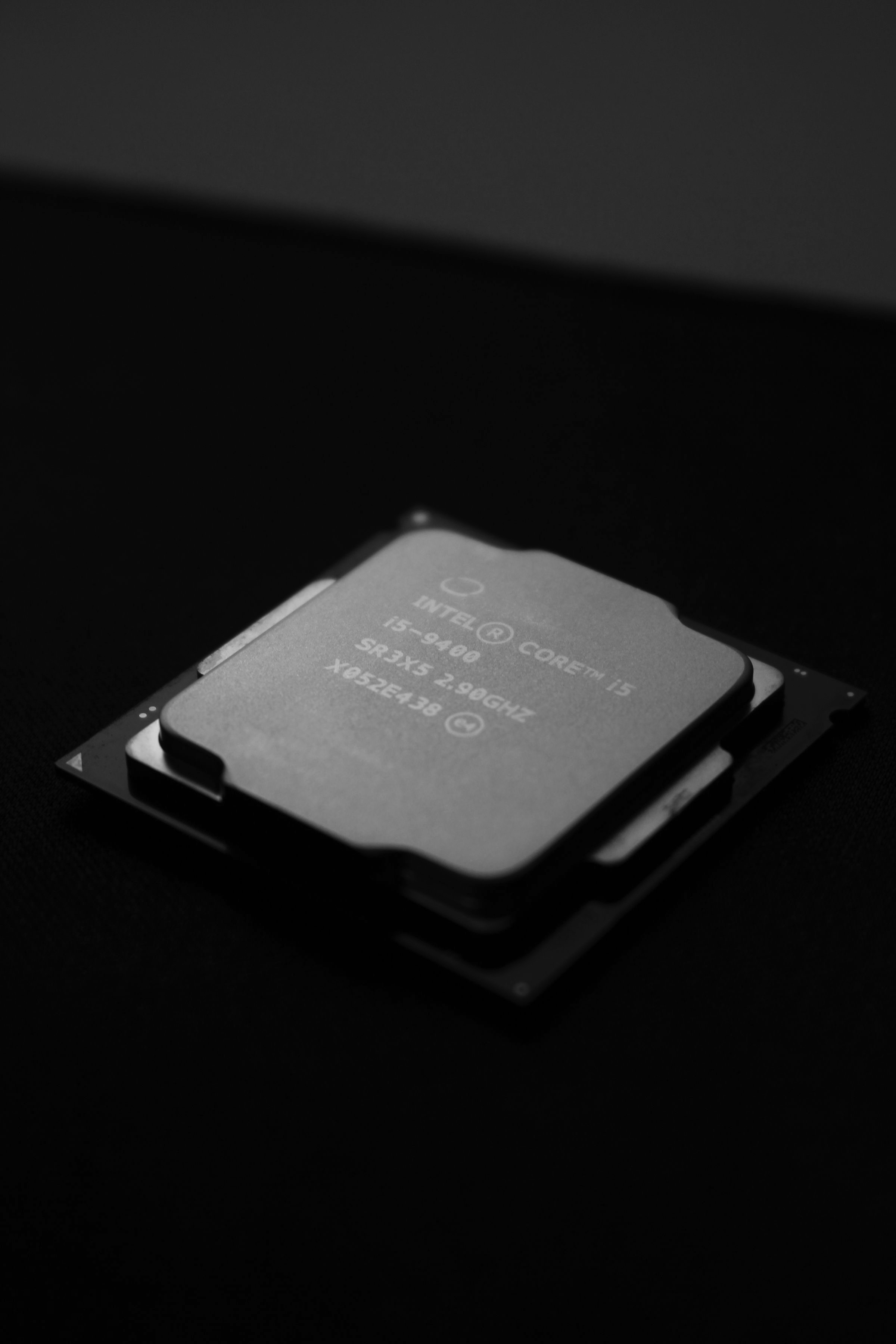 A processor chip on a dark surface, close and monochrome.